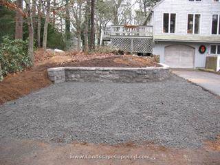 Driveway expansion with stone retaining block wall.